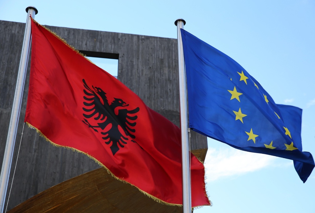 Albanian national flag with double-headed eagle flying proudly beside the European Union flag