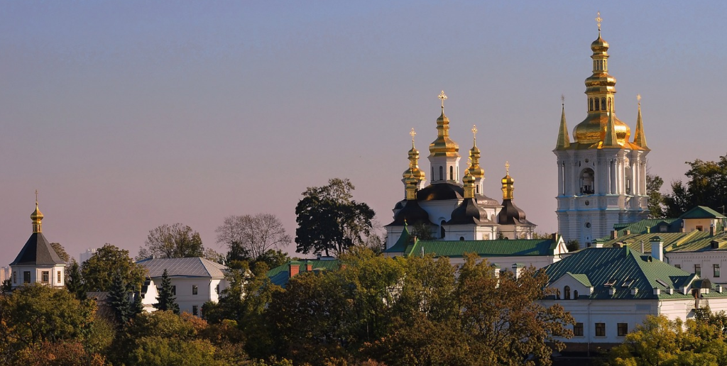 Kyiv skyline with historic golden domed churches and green hills in Ukraine