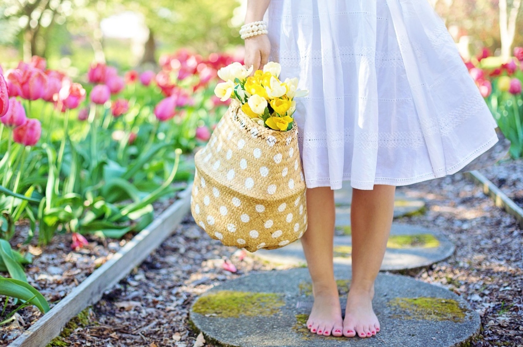 Serbian woman holding basket of spring flowers in garden - domestic warmth and feminine grace